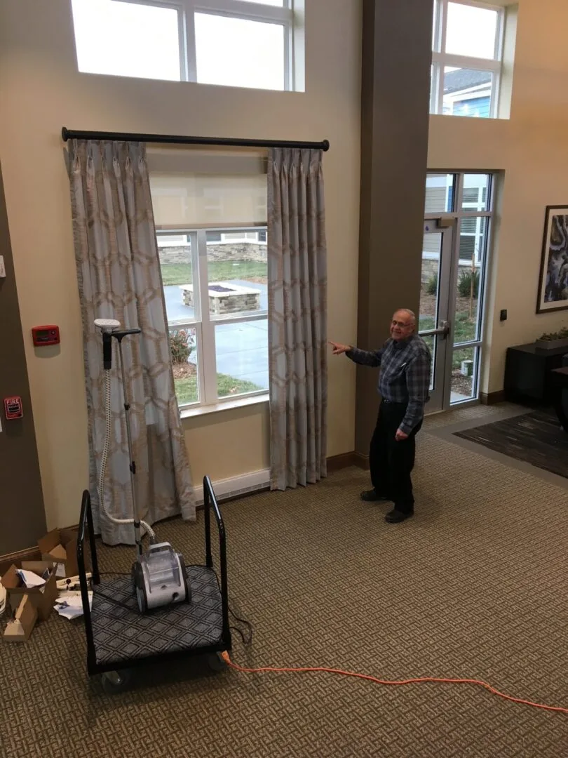 Shutter King USA installer measuring tall windows with drapery in an Indianapolis home