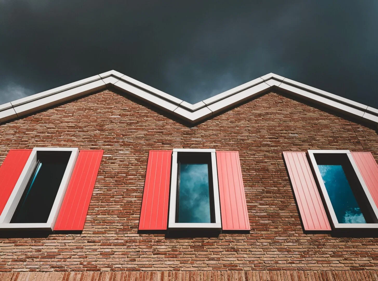 Red storm shutters closed over brick-front windows in the Indianapolis area