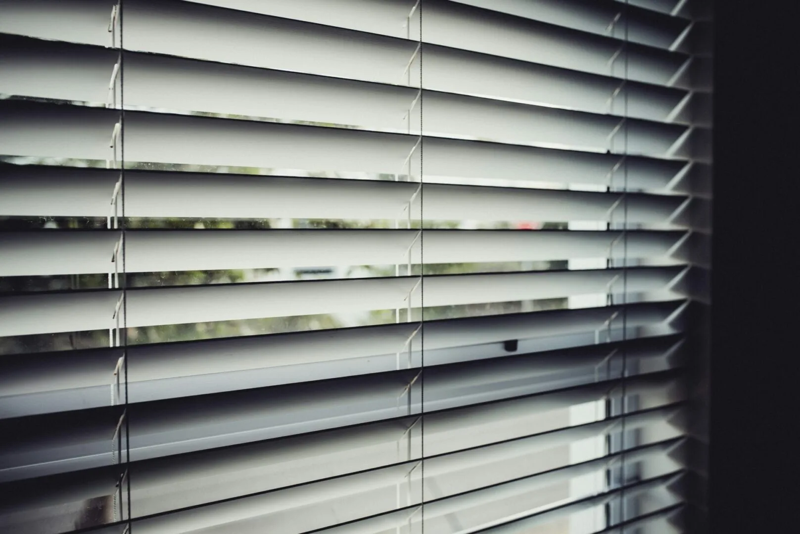 Close-up of white blackout roller blinds installed inside a window frame