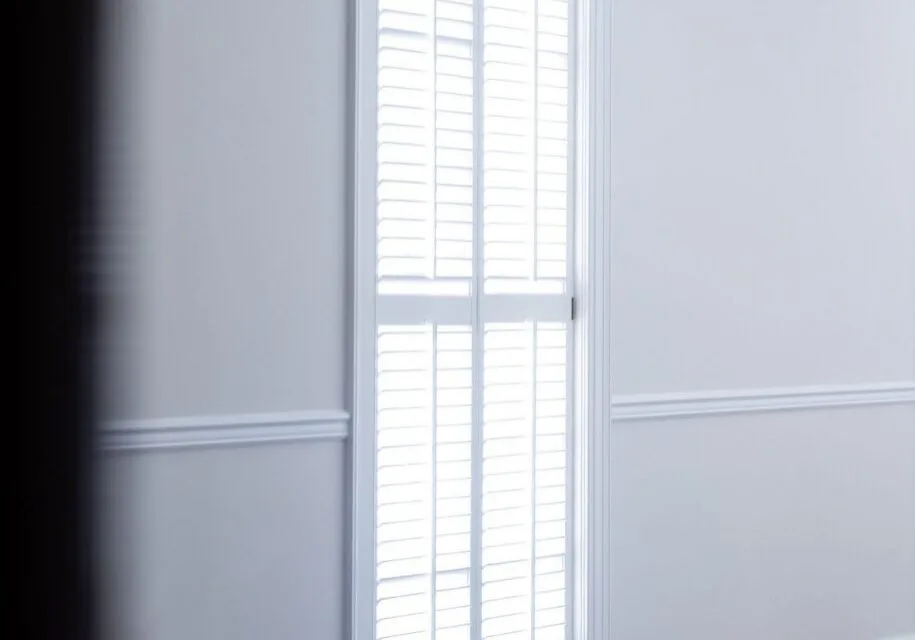 White interior shutters on a tall window in a bright Indianapolis home