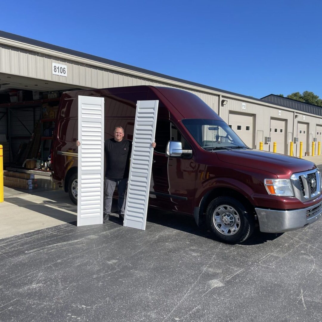 A man standing in front of a van with two ramps.