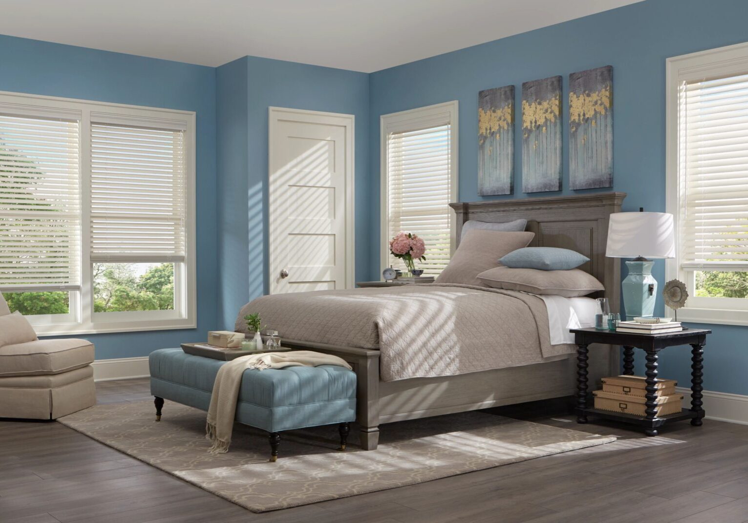 A bedroom with blue walls and white bedding.